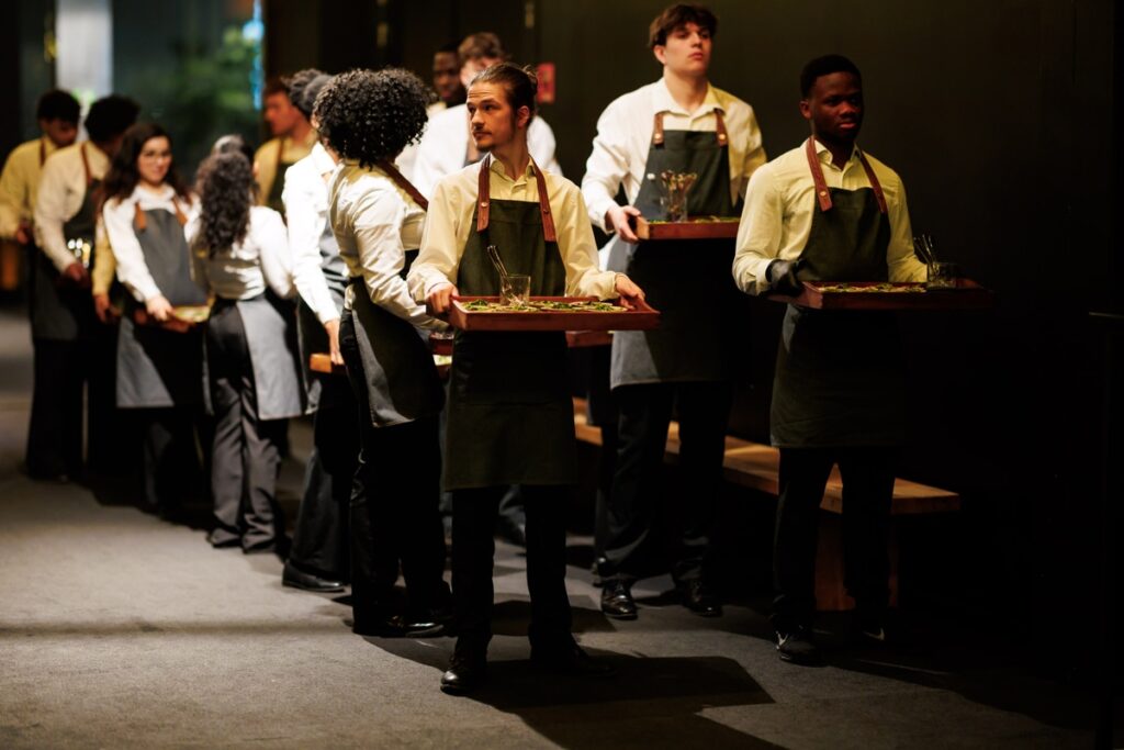 Cateringpersoneel in rij met trays tijdens walking dinner