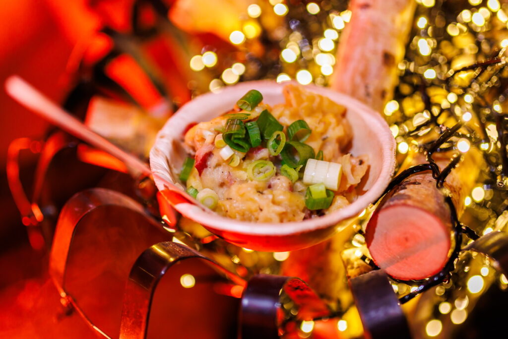 Winterse foodbowl met prei en kaas gepresenteerd tussen feestverlichting